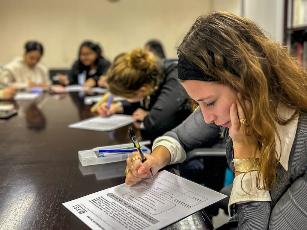 Agnese Aurora Bettini, Youth Empowerment Intern at FSI, alongside other attendees working on their worksheets.